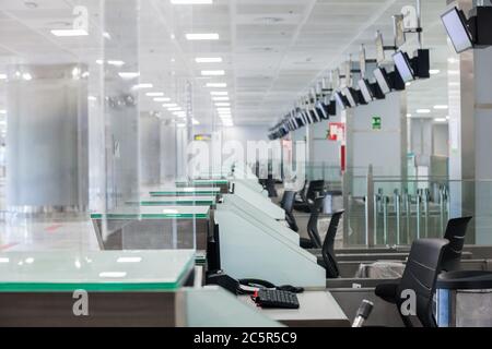 Terminal non utilizzato vuoto, lonuge, banchi di check-in presso l'aeroporto di Tenerife Sud, area partenze, a causa di restrizioni di viaggio per l'epidemia di coronavirus Covid-19. Foto Stock