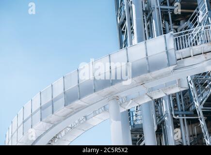 Vista ravvicinata di una costruzione contemporanea di una raffineria industriale di petrolio o di un moderno impianto di produzione di carburante con un ponte rotondo di fronte, multiplo Foto Stock