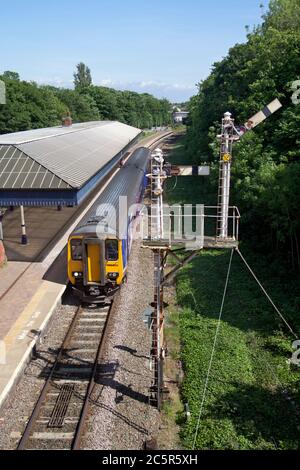 Treno Northern Rail classe 156 che passa il semaforo di staffetta alla stazione ferroviaria di Poulton-le-Fylde Foto Stock