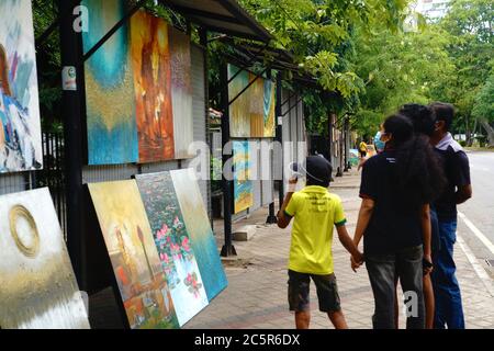 Colombo, Sri Lanka. 4 luglio 2020. La gente vede i dipinti a Green Path, un centro di mostre d'arte all'aperto, a Colombo, capitale dello Sri Lanka, il 4 luglio 2020. Le mostre d'arte all'aperto a Green Path sono scomparse temporaneamente a causa di un coprifuoco a livello nazionale imposto dal governo dello Sri Lanka per prevenire la diffusione del COVID-19 dal marzo 20. Dopo che il coprifuoco fu tolto il 28 giugno, gli artisti tornarono gradualmente qui per esporre le loro opere d'arte. Credit: Tang Lu/Xinhua/Alamy Live News Foto Stock