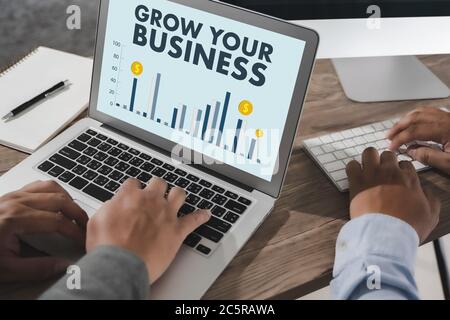 FATE CRESCERE IL VOSTRO BUSINESS computer flare sole, immagine ritagliata maschile freelance seduto al tavolo Foto Stock