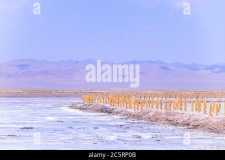 Sul vasto lago salato si trovano lunghi marciapiedi in legno. Il bellissimo scenario del lago salato di Chaka è in estate nella provincia di Qinghai, in Cina. Foto Stock