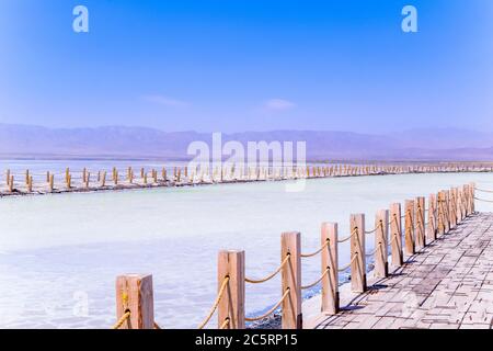 Sul vasto lago salato si trovano lunghi marciapiedi in legno. Il bellissimo scenario del lago salato di Chaka è in estate nella provincia di Qinghai, in Cina. Foto Stock