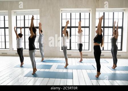 Giovani si adattano a persone multietniche diverse iniziando a fare surya namaskar. Foto Stock