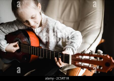 Una giovane caucasion che pratica a suonare la sua chitarra Foto Stock