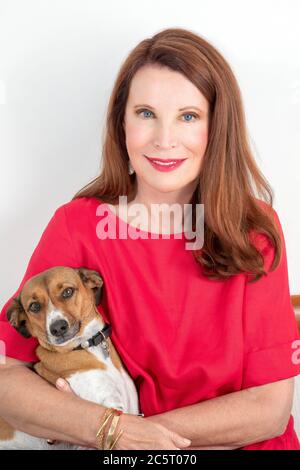 Donna seduta che posa con il suo cane da compagnia Foto Stock