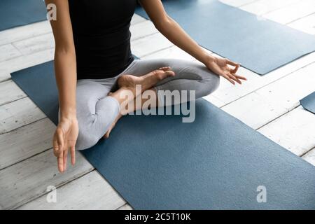 Giovane donna afroamericana che si gode meditando alla lezione di yoga. Foto Stock