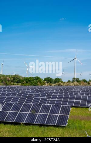 Pannelli solari con turbine eoliche nella parte posteriore visto in Germania Foto Stock