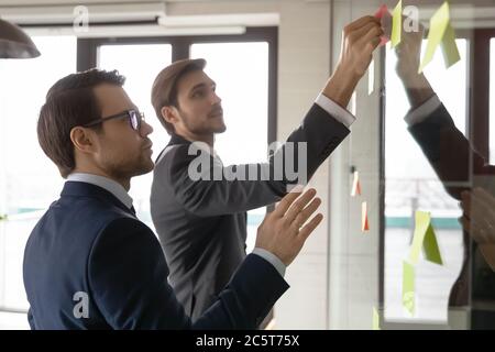 I dipendenti maschi impegnati nel pensiero creativo che sviluppa il piano di affari Foto Stock