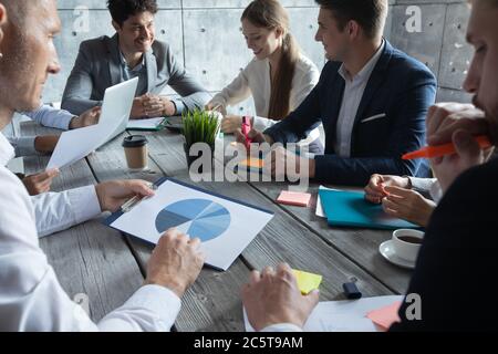 Concetto di team di pianificazione aziendale, persone sedute intorno al tavolo dell'ufficio e che lavorano con i report dei dati finanziari Foto Stock