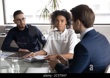 I colleghi multirazziali collaborano alla riunione in carica Foto Stock