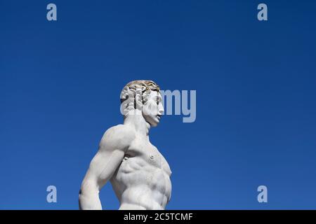 Atleta statua in marmo ritratto contro cielo blu - luce solare Foto Stock