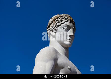 Atleta statua in marmo ritratto contro cielo blu - luce solare Foto Stock