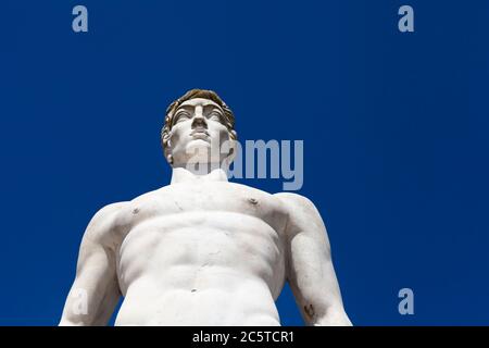 Atleta statua in marmo ritratto contro cielo blu - luce solare Foto Stock