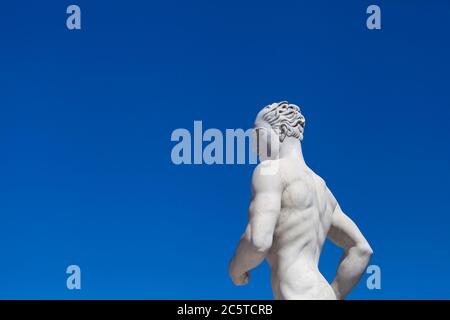 Atleta statua in marmo ritratto contro cielo blu - luce solare Foto Stock