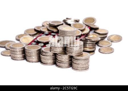 Monete metalliche in euro stack di denaro e delle singole monete sparse su una calcolatrice tascabile Foto Stock