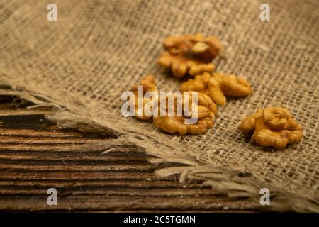 Noci pelate sfuse su un tavolo di legno coperto di tela ruvida. Dieta sana. Dieta di idoneità. Primo piano Foto Stock