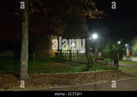 Vialetto pedonale, panchine e torre medievale di notte illuminata da lampade a LED. Estate. Foto Stock