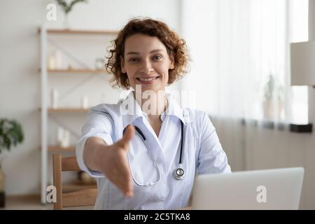 Ritratto di sorridente dottore donna tendere la mano per la stretta di mano Foto Stock