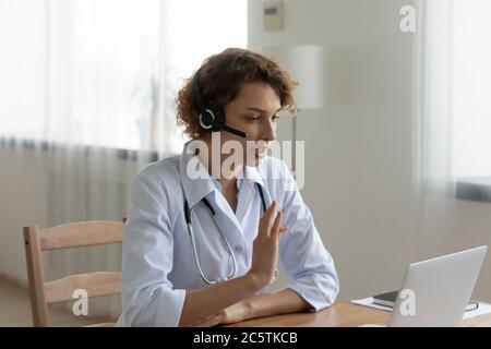 Donna dottore in cuffia hanno videochiamata sul computer Foto Stock