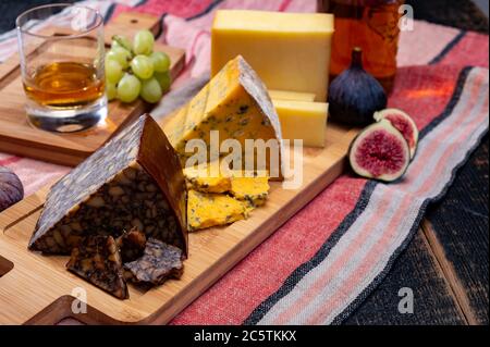 Formaggio irlandese marrone, formaggio blu e un bicchiere di degustazione di un piatto unico whisky irlandese da vicino Foto Stock