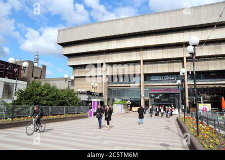 BIRMINGHAM, UK - 19 APRILE 2013: La gente cammina di fronte alla Biblioteca Centrale di Birmingham. L'edificio brutalista era una controversia locale prima che fosse f Foto Stock