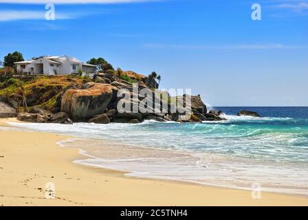 Casa bianca sulla costa rocciosa, edificio tipico sulla riva dell'oceano a Seychelles isola, Mahe Foto Stock