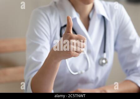 Primo piano di donne medico mostra pollice su Foto Stock