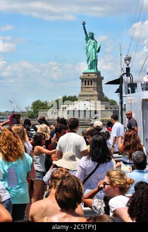 NEW YORK, USA - 6 LUGLIO 2013: I turisti scattano foto della Statua della libertà dal traghetto a New York City, Stati Uniti. Foto Stock