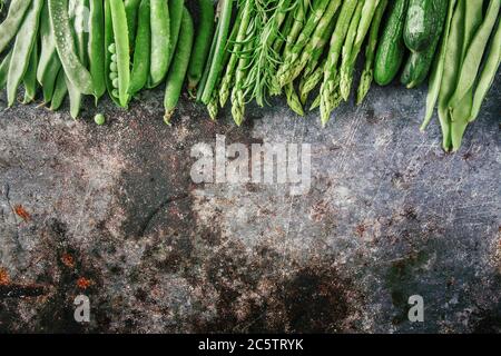 Gruppo di verdure verdi in fila, piatto su pietra grigia, spazio copia Foto Stock