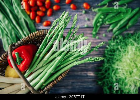 Verdure in cestino su sfondo di legno. Cibi freschi crudi. Vista dall'alto. Messa a fuoco in primo piano Foto Stock