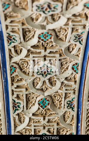 Particolare di piastrelle decorative colorate in ceramica in un arco di porta del Palazzo Bahia a Marrakech, Marocco. Mettere a fuoco il fiore al centro della foto Foto Stock