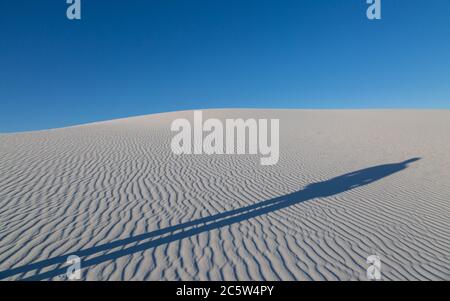 Una lunga ombra serale di un uomo, nel Monumento Nazionale delle White Sands, New Mexico Foto Stock