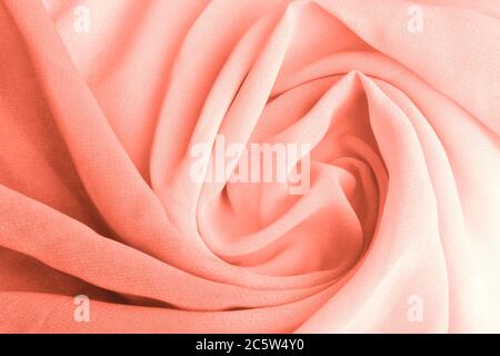 Corallo rosa delicato tessuto drappeggiato e filato. Primo piano. Foto Stock