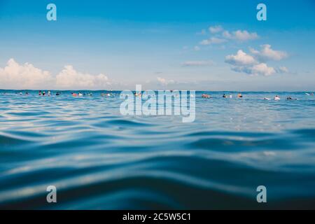 16 aprile 2020. Bali, Indonesia. Surfers in linea in su in oceano. Surfisti in oceano durante il surf. Foto Stock