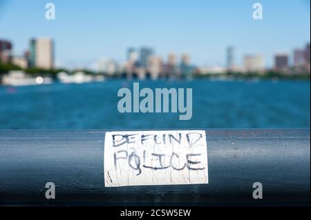 Adesivo della polizia Defund sulla ringhiera in ferro che si affaccia sul fiume Charles e sullo skyline della città di Boston. Foto Stock