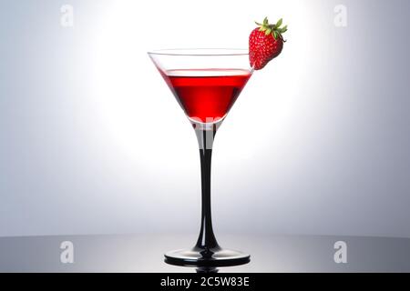 Cocktail rosso con liquore e fragola matura fresca in bicchiere martini Foto Stock