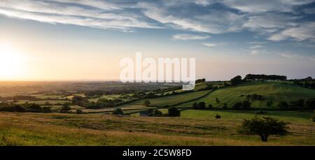 Il sole che tramonta getta una luce dorata sul paesaggio agricolo della Valle d'Oro del Gloucestershire del Sud sotto la scarpata del Cotswold Hil Foto Stock