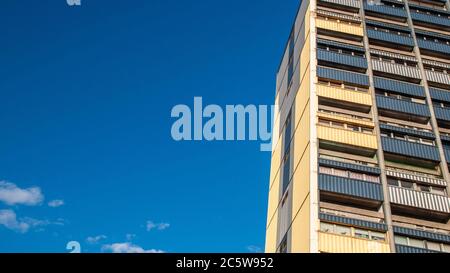 Persevere Court, un colorato edificio a torre alto del XX secolo di appartamenti del consiglio, parte della Cittadella Estate, sorge in un cielo blu sopra Leith in Edi Foto Stock