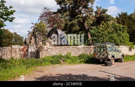 Gli alberi crescono attraverso il tetto rovinato di una casa di gatehouse a Middleton Hall a Midlothian, Scozia. Foto Stock