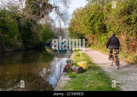 Bagno, Inghilterra - 19 Aprile 2011: Un ciclista sulle navi in transito sul Kennet & Avon Canal alzaia vicino a Bath in Somerset. Foto Stock