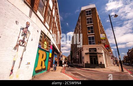 Londra, Inghilterra, Regno Unito - 4 luglio 2010: I pedoni passano davanti alla Street art sugli edifici di Rivington Street a Shoreditch, Londra est. Foto Stock