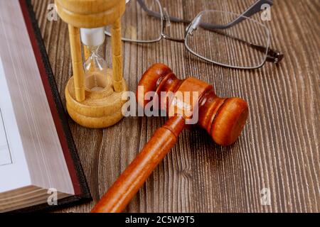 Aprire il libro di legge con una gavel di un giudice di legno sul tavolo in una sala di giustizia o di un ufficio di applicazione della legge simbolo di giustizia, concetto di legge Foto Stock