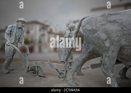 Ponte de Lima, Portogallo - 13 maggio 2020: Statua di bronzo che rappresenta il duro lavoro delle famiglie di agricoltori Minho nel passato, utilizzando buoi per coltivare la terra. Foto Stock