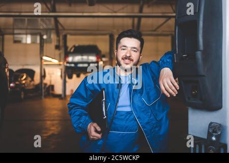 Ritratto di un meccanico di auto positivo in un garage Foto Stock