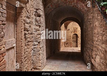 Todi, Umbria, Italia: Antico vicolo con sottopassaggio nella città medievale italiana - pittoresco angolo di città oscura Foto Stock
