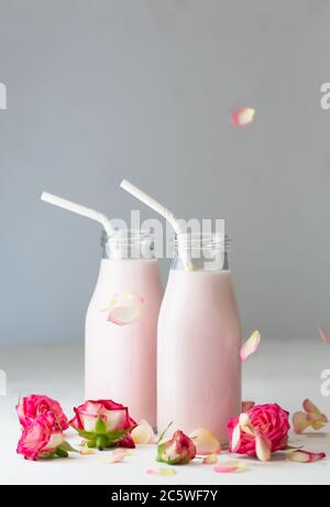 Il latte lunare si prepara con il fiore rosa in due bottiglie. Drink rilassante alla moda a base di tradizioni ayurvediche Foto Stock