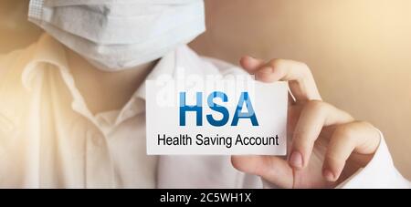 Medico che tiene una carta con testo HSA Health Saving account Foto Stock