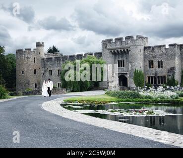 Passeggiata tra sposi e sposi al luogo di nozze di Allington Castle, Allington, Maidstone, Kent, Inghilterra, Regno Unito. Costruito in pietra, ormeggiato, costruito nel 12 ° e 13 ° secolo Foto Stock