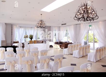 Sala per cerimonie o ufficio di registrazione vuota e chiusa per matrimoni con splendidi lampadari moderni. Foto Stock